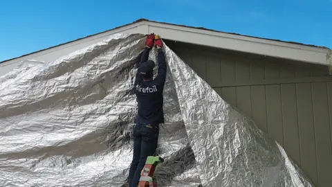 A FireFoil™ crew installing a shield over a gable end.