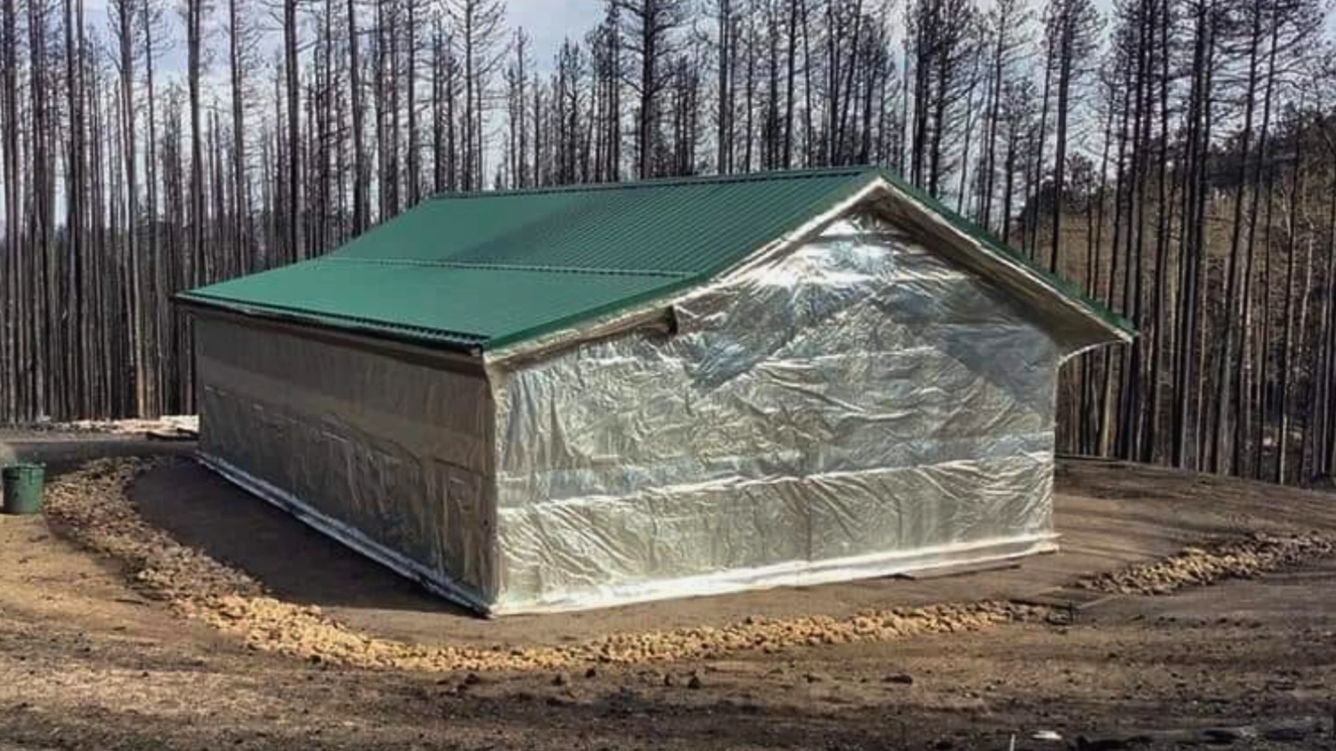 Cabin with partial FireFoil protection in burned forest area