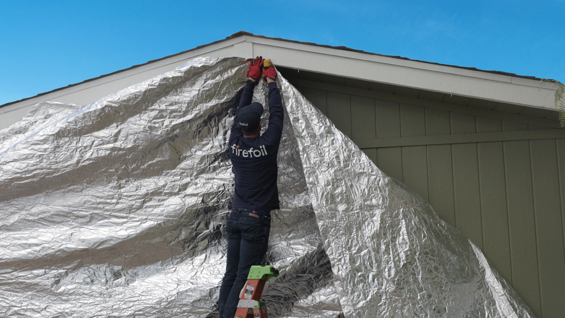 FireFoil technician installing protective material on building exterior